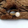 la bague gentiane, ajustable et ornée d'une pierre naturelle quartz blanc, est en acier inoxydable doré.