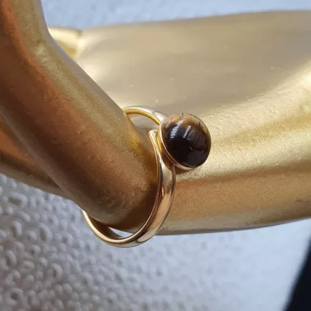 la bague gentiane, ajustable et ornée d'une pierre naturelle oeil de tigre, est en acier inoxydable doré.