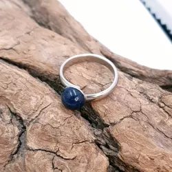 la bague gentiane, ajustable et ornée d'une pierre naturelle lapis lazuli, est en acier inoxydable argenté.