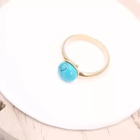 la bague gentiane, ajustable et ornée d'une pierre naturelle turquoise, est en acier inoxydable doré.