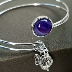 Le bracelet jonc Sylvaine est en acier inoxydable argenté, réglable, avec un cabochon en agate et une breloque.