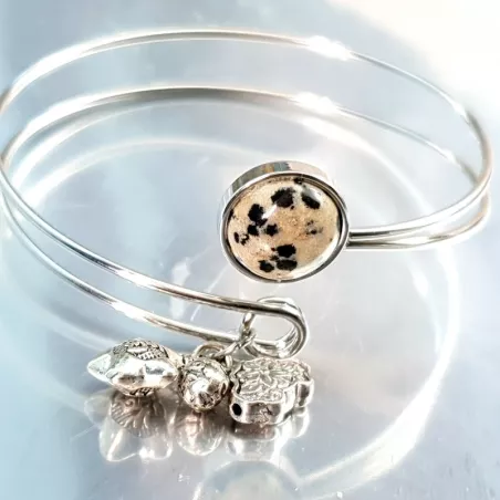 Le bracelet jonc Sylvaine est en acier inoxydable argenté, réglable, avec un cabochon en agate et une breloque.