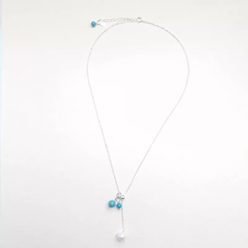 Le Collier Chiara est un collier pendentif réglable avec perle d'eau en argent et turquoise