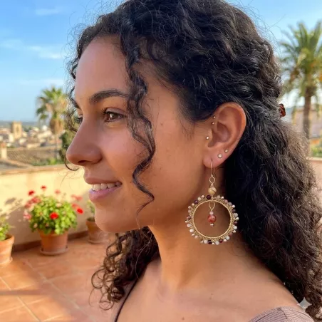 Boucles d’oreilles Setaria portées par une jeune femme, bijou pendante artisanal en acier inoxydable