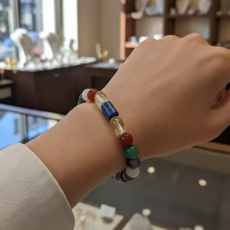 Bracelet doré en pierres naturelles porté au poignet sur peau claire