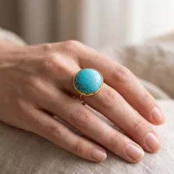 Bague Milet dorée en acier inoxydable avec cabochon turquoise bleue, portée à la main
