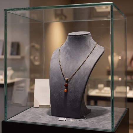 Collier Vintage couleur bronze présenté sur buste derrière une vitrine