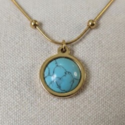 Gros plan du pendentif du collier Séléné en acier inoxydable doré avec cabochon en turquoise
