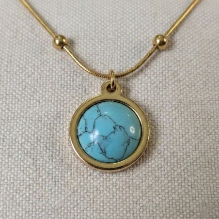 Gros plan du pendentif du collier Séléné en acier inoxydable doré avec cabochon en turquoise